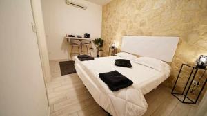 维罗纳Langolo di laura borgo roma destiny home 3的卧室配有白色床和黑色毛巾