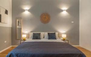 塔兰托SoClà Boutique Hotel的一间卧室配有一张大床和两盏灯