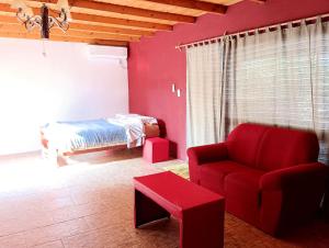 萨利纳斯Entre naturaleza a 1 cuadra de la playa/Jacuzzi的客厅配有红色的沙发和床。