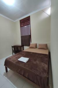 日惹OYO 93173 Khazanah Room Syariah的卧室配有床、椅子和窗户。