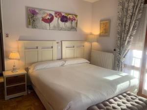 莱尔马多卡旅馆的卧室设有一张白色大床和一扇窗户。