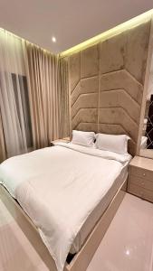 富查伊拉Luxury Villa 5 bedrooms with sea view and free boat的卧室配有一张带白色床单和枕头的大床。