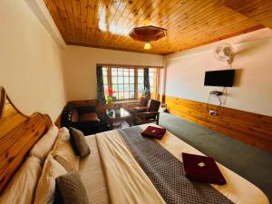 马拉里Sita Hotel & Cottage, Manali的一间卧室配有一张床、一张书桌和一台电视