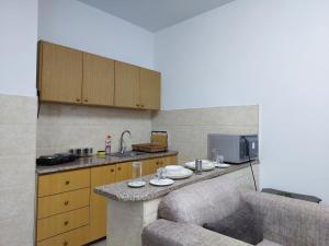 安曼Cozy Home 2的厨房配有带长沙发和台面的台面