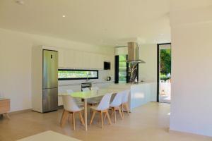 卡拉恩·布拉內斯Villa SONIA的厨房配有餐桌和白色椅子