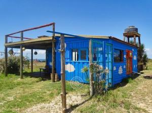 凯博波洛尼奥Casita de Mar的靠近海洋的一片土地上的蓝色小房子