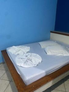贝洛奥里藏特Hotel Angely的一张带白色床单和毛巾的床
