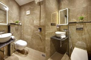 新德里BLESS INN - Near Connaugt Place的浴室配有2个盥洗盆、卫生间和淋浴。