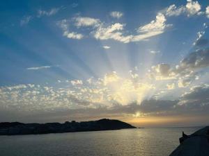 拉科鲁尼亚Centro, playa y puesta de sol的水体上空的云天