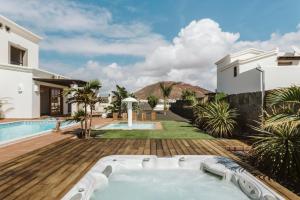 普拉亚布兰卡Villa Marabú的享有庭院内带热水浴池的房子的景致