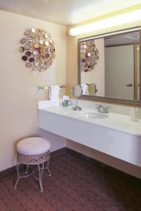 拉伯克MCM鲁波科典雅套房酒店的一间带水槽、镜子和凳子的浴室