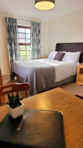 Horsford教堂农场旅馆的酒店客房配有一张床和一张桌子,桌子上装有四面 ⁇ 