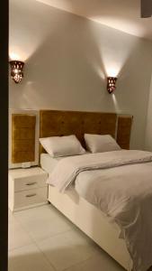 卢克索Moon House of Luxor的卧室配有一张床,墙上有两盏灯