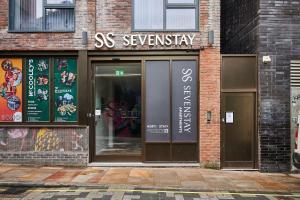 利物浦Host & Stay - Sevenstays Aparthotel的砖楼上带有 ⁇ 门标志的商店前部