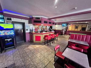 阿伯丁Brig Inn Hotel的餐厅设有酒吧,配有红色椅子和视频游戏