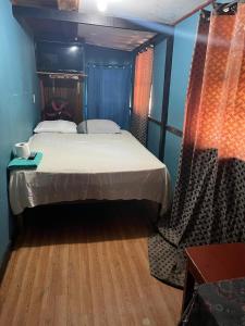 Coxen HoleHotel Gusto Bueno的一间卧室设有一张大床,铺有木地板