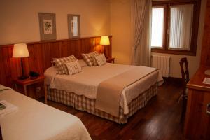 坎波斯杜若尔当Hotel Solar d'Izabel的酒店客房设有两张床和两盏灯。