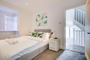 罗姆福特Exquisite 5-Bedroom in London and Essex - Sleeps 10 with Free Parking的一间白色的卧室,配有床和楼梯