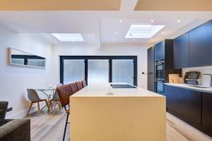 罗姆福特Exquisite 5-Bedroom in London and Essex - Sleeps 10 with Free Parking的厨房以及带桌椅的起居室。
