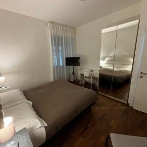 波坦察ESSENTIAL ROOM & PARKING in Centro Città con Parcheggio Privato e WIFI的一间卧室配有一张床、一张书桌和一面镜子