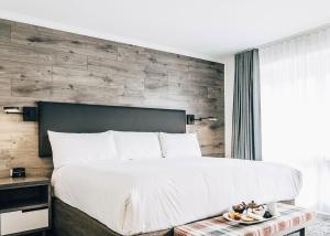 夏洛特顿波纳尔酒店的一间卧室设有一张带木墙的大床