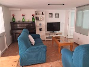 梅里那德奥拉菲Alojamiento Casa Piano的客厅配有2把蓝色椅子和电视