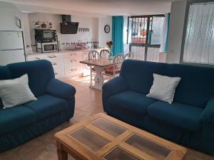 梅里那德奥拉菲Alojamiento Casa Piano的客厅配有2张蓝色的沙发和1张桌子