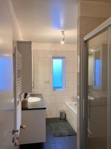 阿克雷里Great apartment in Akureyri的一间带水槽和浴缸的浴室以及窗户。