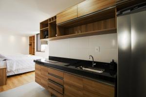 伊列乌斯Ilhéus Praia Hotel的一个带水槽的厨房和一张位于客房内的床