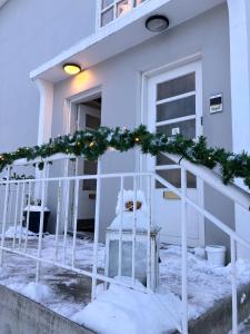 阿克雷里Great apartment in Akureyri的白色房子,楼梯上装饰着圣诞花