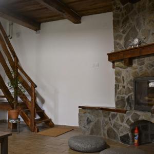 瑙吉伯尔热尼Bogáncs Vendégház - Nagybörzsöny的一间带石头壁炉和楼梯的客厅