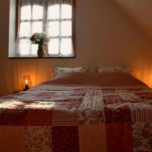 瑙吉伯尔热尼Bogáncs Vendégház - Nagybörzsöny的卧室里一张带红白色被子的床