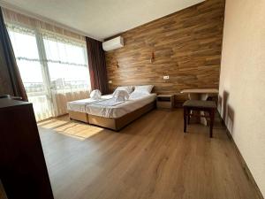 斯特雷尔恰Бонита Хотел Спа的一间卧室设有一张床和木墙