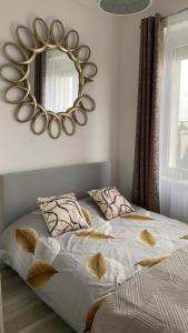 比得哥什Apartament Gdańska 230的卧室配有一张壁挂镜子的床