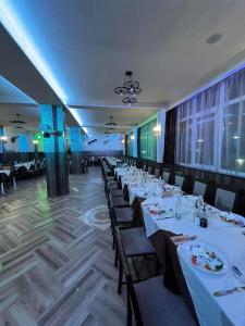 斯特雷尔恰Бонита Хотел Спа的用餐室配有桌椅和白色的桌布