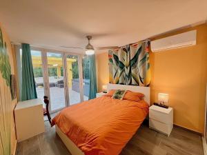 阿瓜达Casa De Sol Family Home Near Rincon & Beach的一间卧室配有带橙色床单的床和窗户。