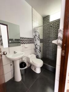 卡哈马卡HOTEL NILA的白色的浴室设有水槽和卫生间。