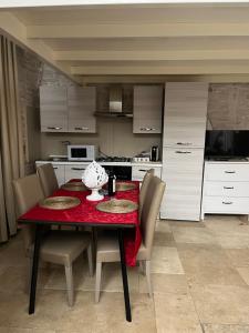 泰尔利齐Augustus luxury suite的厨房配有桌椅和红色桌布
