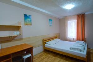 基辅珀多斯基旅舍的一间小卧室,配有一张床和一张书桌
