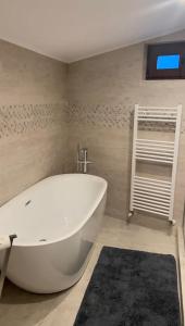 布朗La Maison des Rêves - Bran的浴室内设有大型白色浴缸。