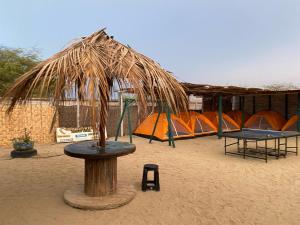 曼克拉Pepon Surf Camp的沙子里一组帐篷,配有桌子