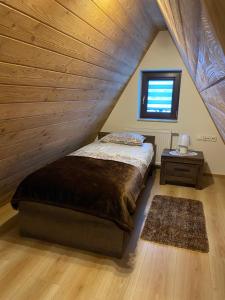 新塔尔格Apartamenty Natalii的一间卧室设有一张床和木制天花板