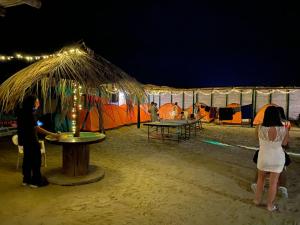 曼克拉Pepon Surf Camp的站在帐篷前的男人和女人