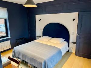 勒藏讷LA PARCELLE的一间卧室设有一张蓝色墙壁的大床