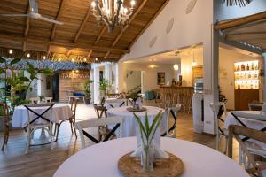 拉斯特拉纳斯TAKUMA BOUTIK HOTEL的一间带白色桌椅的餐厅和一间厨房