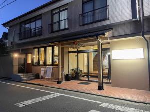 天草市Eimiya Ryokan - Vacation STAY 36252v的城市街道上的建筑,前面有标志