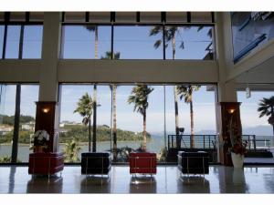 天草市Hotel Alegria Gardens Amakusa - Vacation STAY 40453v的大堂种有棕榈树,享有海景