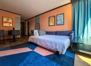 圣地亚哥APT Serviced Apartments Santiago的一间卧室配有一张床和一张蓝色的沙发