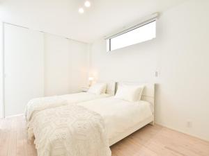 淡路Seagull east coast Awaji - Vacation STAY 21943v的白色卧室设有两张床,配有窗户