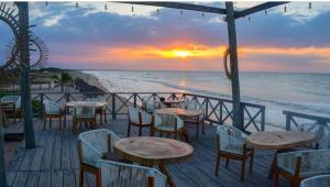 CamaronesMar Azul - Playa y Turismo的海滩上的餐厅,配有桌椅